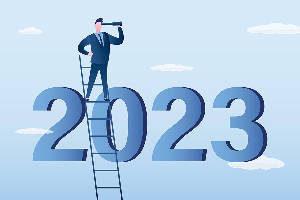 A man standing on top of a ladder in front of the number 2 0 2 3.